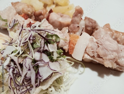 Italian dish with meat skewers, salad and baked potatoes