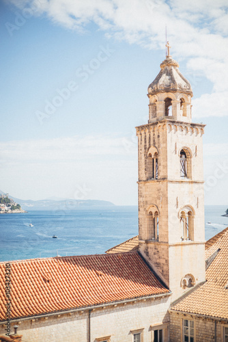 bell tower of dominican church with view of the sea in the background, dubrovnik, croatia