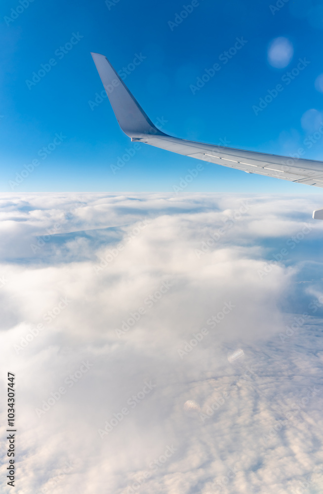 View from the airplane window at a beautiful cloudy sky and the airplane wing View from the airplane window at a beautiful cloudy sky and the airplane wing