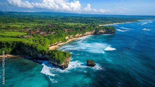 An aerial view of Diamond Beach, Bali, showcasing vibrant turquoise waters crashing against the rugged cliffs, with a lush green outcrop jutting into the ocean and a small pristine beach nestled betwe