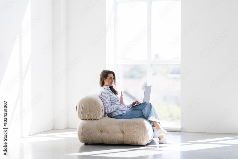 Young woman sitting cross-legged using laptop at home Young woman sitting cross-legged using laptop at home
