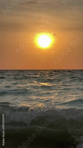 Olas en càmara lenta con cielo naranja al atardecer en el mar caribe