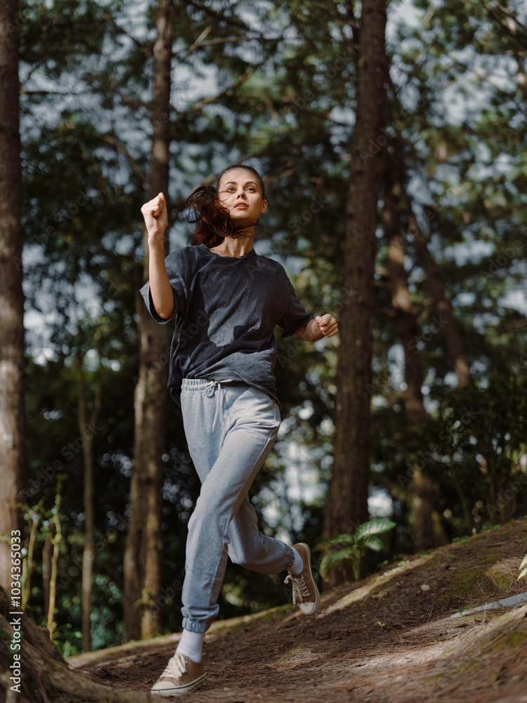 Energetic young woman jogging on a forest trail, wearing comfortable sportswear and enjoying a workout in nature Fitness and wellness concept Energetic young woman jogging on a forest trail, wearing comfortable sportswear and enjoying a workout in nature Fitness and wellness concept
