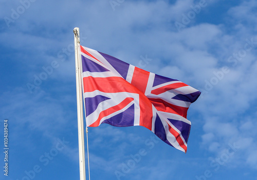 A vibrant Union Jack waving proudly under a clear blue sky, symbolizing British heritage and unity