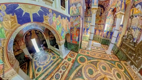 Topola, Serbia, Sept 2,2024: Wide angle view of the interior of the orthodox church of St. George in Topola, Serbia, highlighting the colorful stone floor and religious frescoes on walls and columns photo