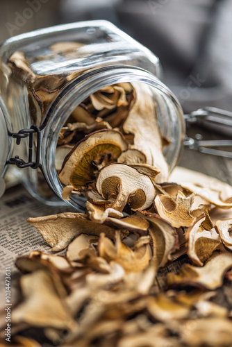 Dried porcini mushrooms. Sliced boletus in jar on wooden table.