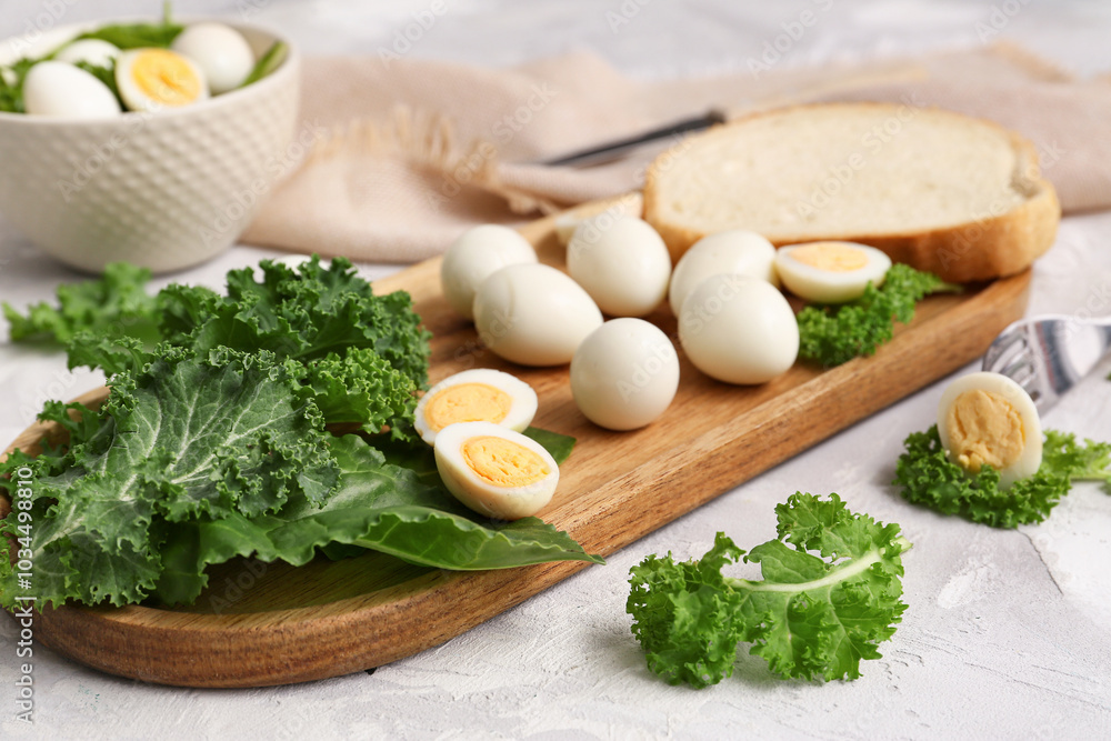 Wooden board with fresh boiled quail eggs and greens on light background, closeup Wooden board with fresh boiled quail eggs and greens on light background, closeup
