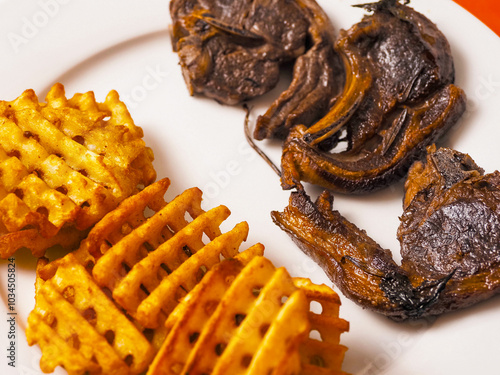 Dinner with well cooked lamb chops on the bone, potato lattice shape chips and fresh salad with cream. High quality products. Tasty properly meal. Fine simple food. photo