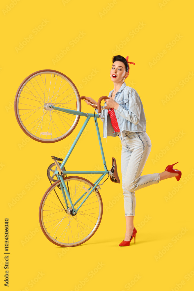 Young pin-up woman with bicycle on yellow background Young pin-up woman with bicycle on yellow background