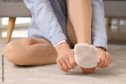 Woman sitting on carpet flo...