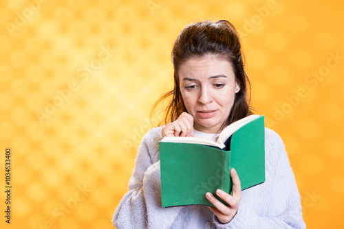 Woman sobbing while reading sad book, enjoying hobby during leisure time. Bookaholic person with novel in hands weeping, enthralled by emotional story, isolated over studio background