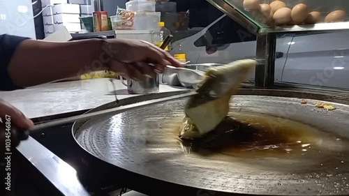 egg martabak. martabak seller frying martabak in a frying pan. Martabak sellers cook in frying pans with hot cooking oil. local Indonesian food.
