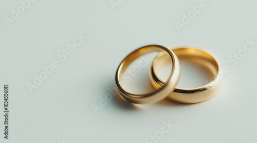 Elegant gold wedding rings resting on a soft surface in a bright setting, symbolizing love and commitment.