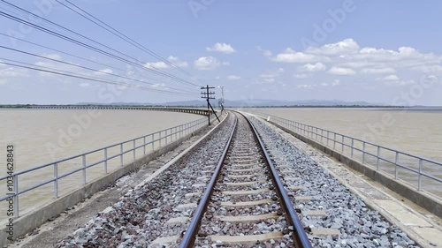 Aerial view of Thai local train on railway bridge at Pa Sak Jolasid Dam, the biggest reservoir in central Thailand, in Lopburi province with sea shore in transportation and travel concept photo