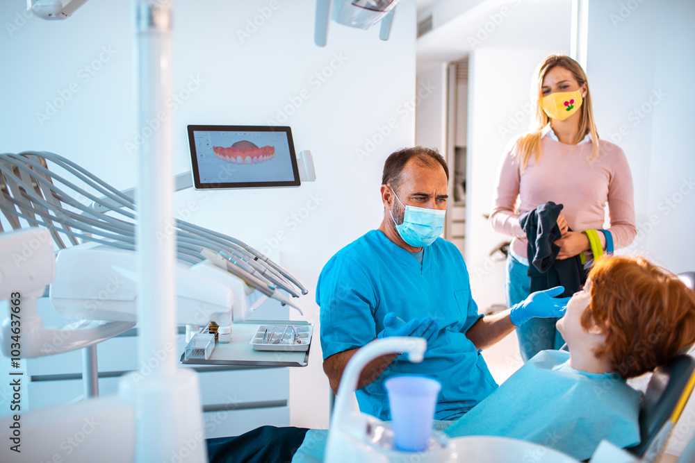 Dentist working on a little boys teeth with his mother next to him Dentist working on a little boys teeth with his mother next to him