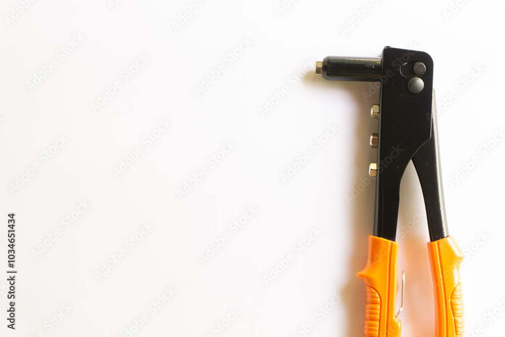 Rivet tool with orange handle and silver blind rivets for hand rivets of various layouts isolated on white background. Rivet tool with orange handle and silver blind rivets for hand rivets of various layouts isolated on white background.