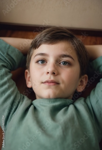 Serene young individual with calm expression resting with hands behind head against soft background 