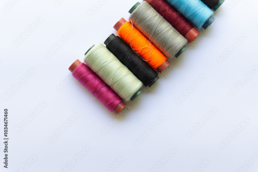 Top view of colorful threads on white background with various layouts. Top view of colorful threads on white background with various layouts.