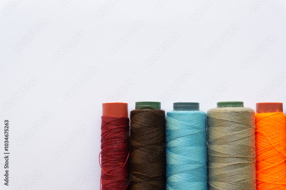 Top view of colorful threads on white background with various layouts. Top view of colorful threads on white background with various layouts.