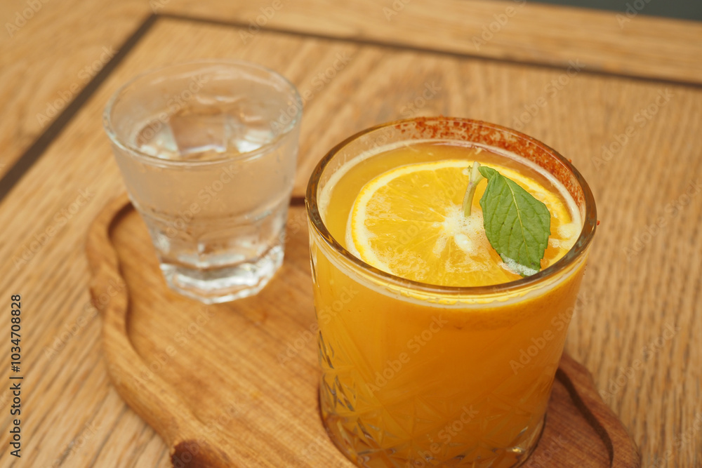 Enjoy a Refreshing Citrus Drink with Mint, Served Alongside a Cool Glass of Water Enjoy a Refreshing Citrus Drink with Mint, Served Alongside a Cool Glass of Water