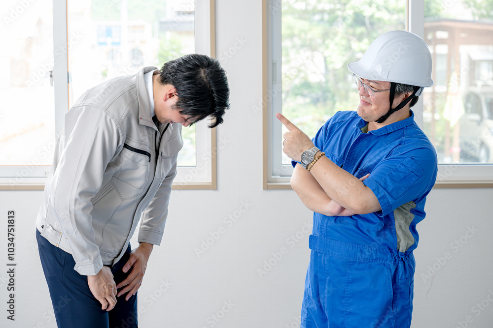 Obraz premium 指差す作業員と頭を下げる作業員