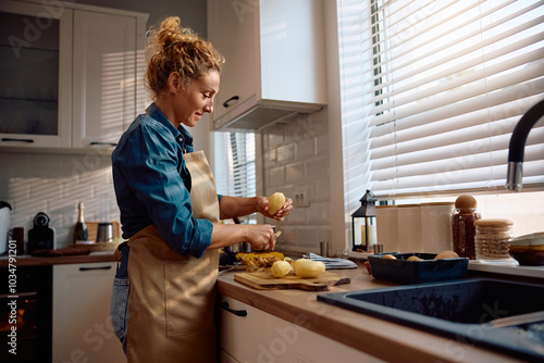 Canvastavla Smiling woman preparing food for Thanksgiving dinner in kitchen.