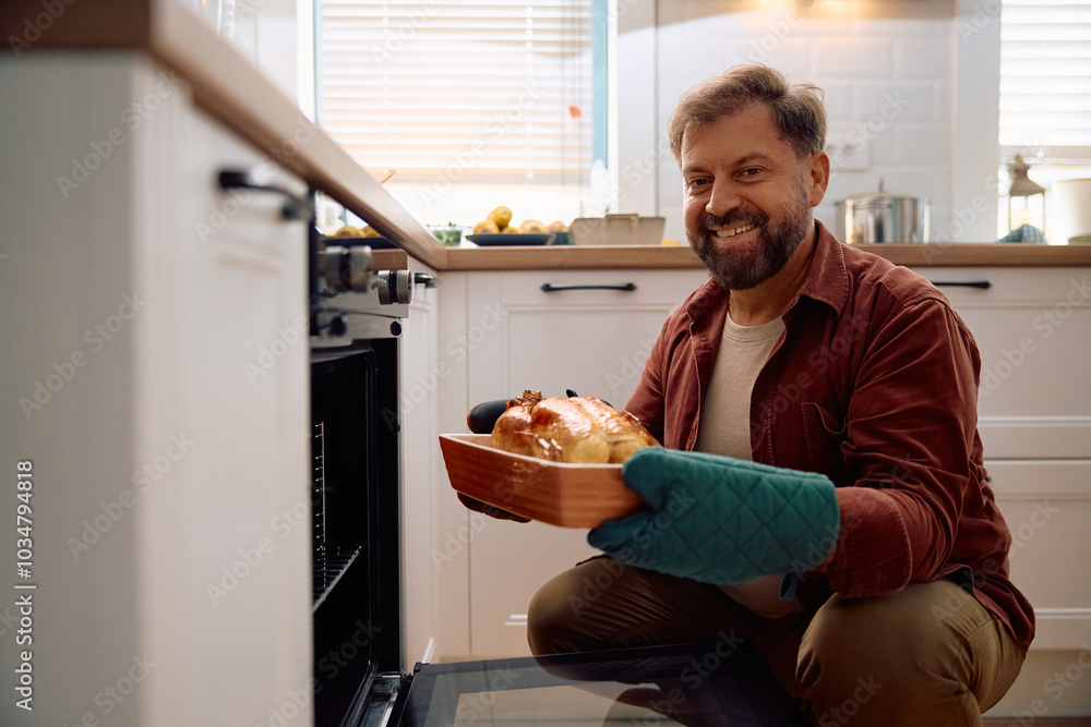 Happy man with freshly roasted turkey in kitchen looking at camera. Happy man with freshly roasted turkey in kitchen looking at camera.