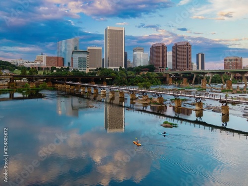 People kayaking and the T. Tyler Potterfield Memorial Bridge crossing the James River. In the distance is the downtown city skyline. Richmond, Virginia, United States.