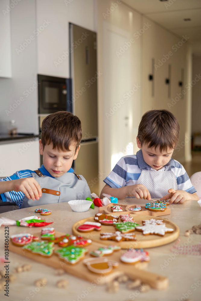 Happy family mother and children in aprons making Christmas cookies together while cooking Happy family mother and children in aprons making Christmas cookies together while cooking