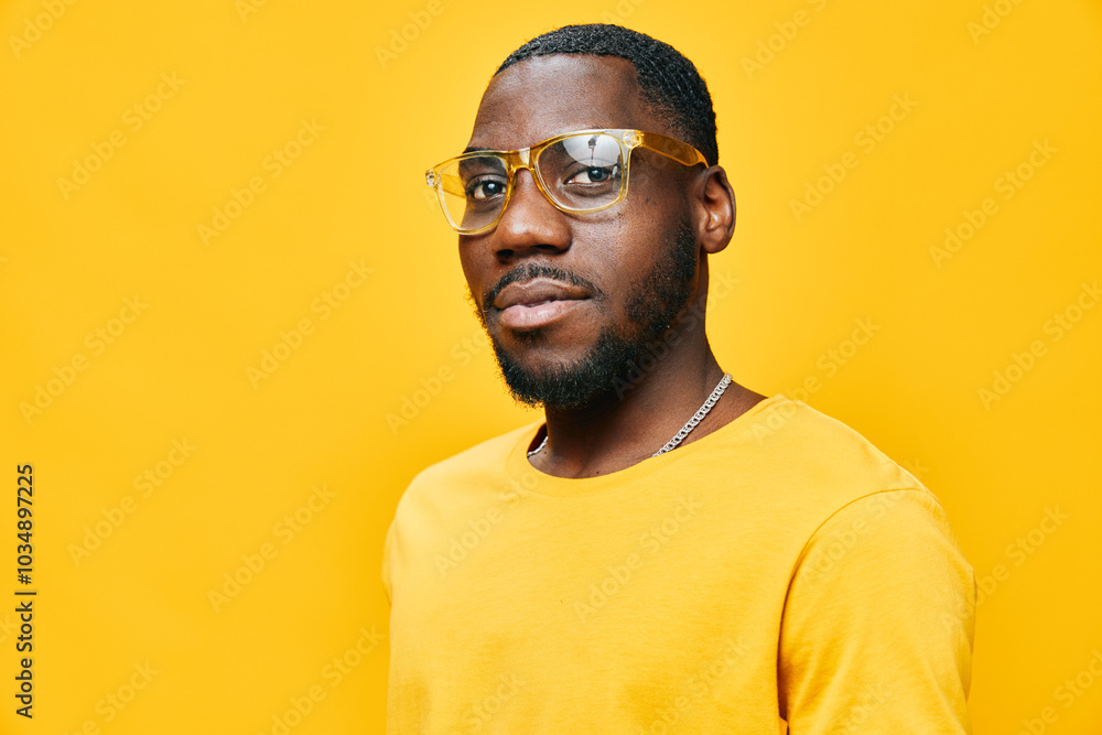 African male model in stylish yellow outfit, with glasses, exuding confidence and style against a vibrant yellow background, perfect for fashion or lifestyle themes African male model in stylish yellow outfit, with glasses, exuding confidence and style against a vibrant yellow background, perfect for fashion or lifestyle themes