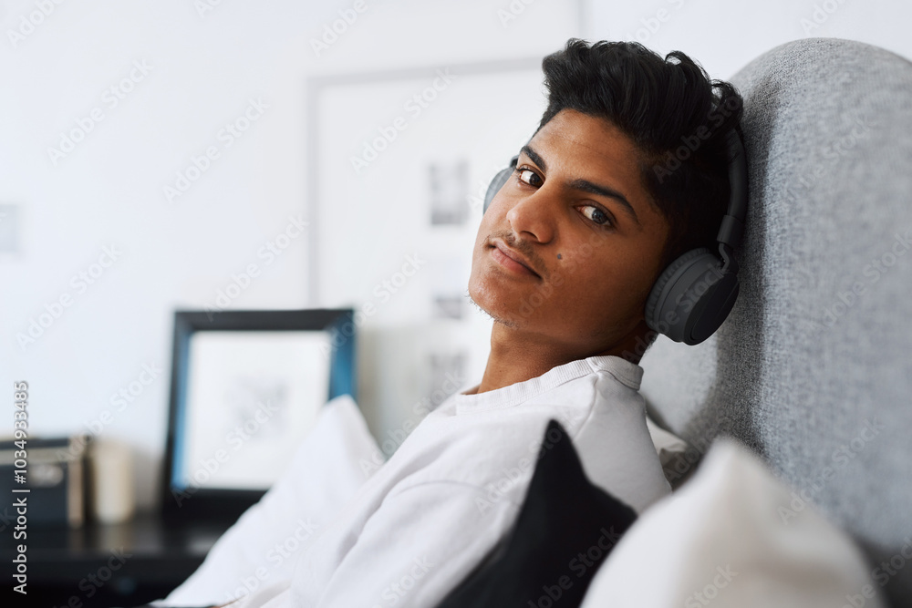 Teenager, headphones and portrait of boy in bedroom for wellness and listening to song. Face, relax or chilling with radio in home for streaming track, audio and update of music playlist in India Teenager, headphones and portrait of boy in bedroom for wellness and listening to song. Face, relax or chilling with radio in home for streaming track, audio and update of music playlist in India