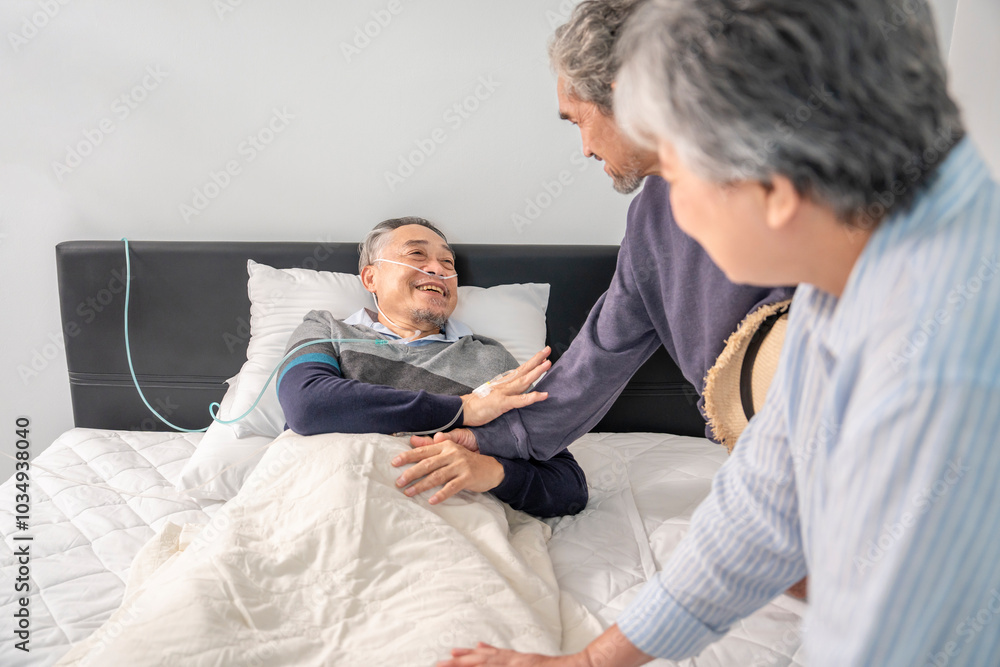 Obraz premium scene of old man patient lying on bed with IV drip and oxygen,smiling and talking with friends who visit him,senior couple friends giving encouragement beside