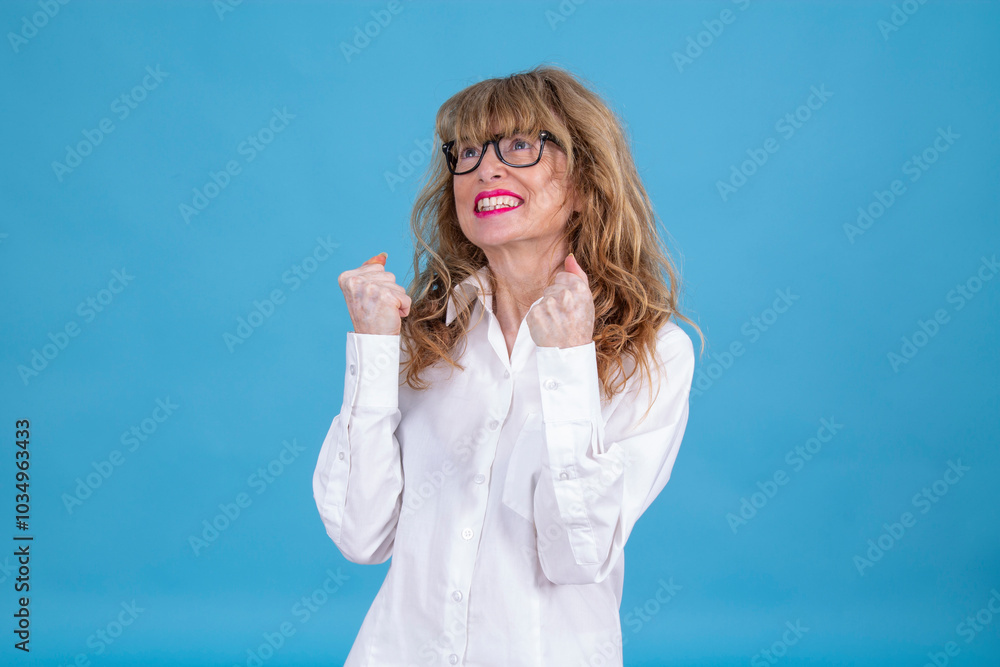 Mature woman with success gesture on blue background Mature woman with success gesture on blue background