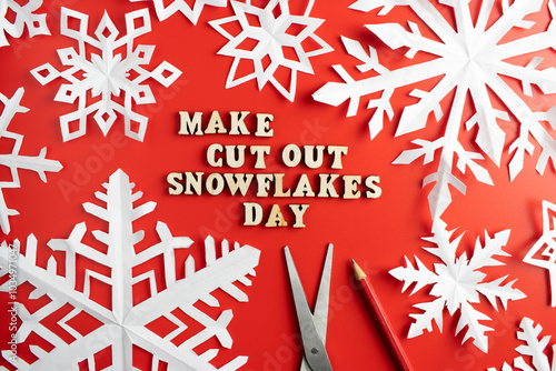 paper cut out snowflakes with make cut out snowflakes day wording, on red background. 