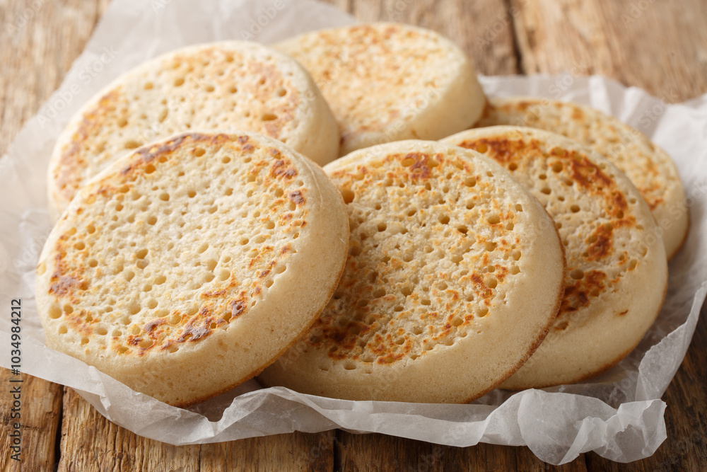 Tradition hot buttered crumpets closeup on parchment on the table. Horizontal Tradition hot buttered crumpets closeup on parchment on the table. Horizontal