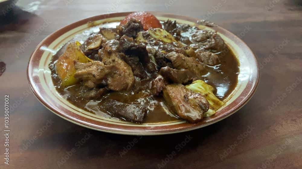 Tongseng delicious food served on a plate. Goat meat stew cooked with sweet soy sauce, coconut milk, sliced cabbage, and tomatoes. Commonly found in Central Java, from Surakarta to Yogyakarta. Tongseng delicious food served on a plate. Goat meat stew cooked with sweet soy sauce, coconut milk, sliced cabbage, and tomatoes. Commonly found in Central Java, from Surakarta to Yogyakarta.