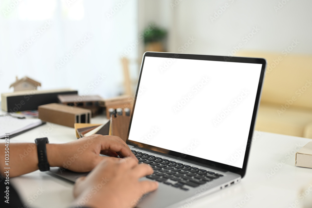 Cropped shot of architect man typing on laptop working on new project at bright modern office Cropped shot of architect man typing on laptop working on new project at bright modern office