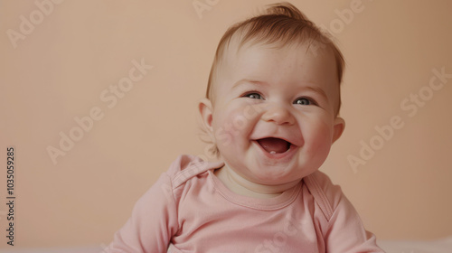 Joyful Caucasian baby with light hair laughing in a soft pink outfit