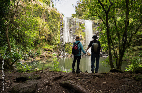 Obraz na płótnie Couple holding hands and enjoying the view of Te Wairere Waterfall. Bay of Islands. w salonie