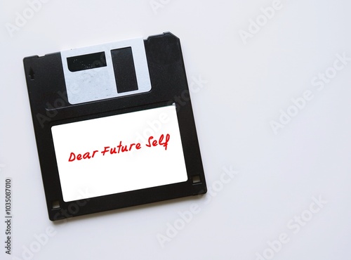 Fotografie Floppy disk on copy space white background with tag DEAR FUTURE SELF, letter to convey message to future you