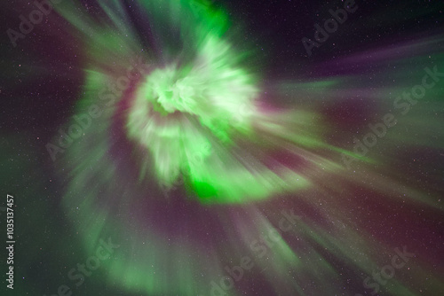 A bright green, pink, red and purple auroral corona, northern lights in Tromso, Norway. Aurora borealis with lots of stars photo