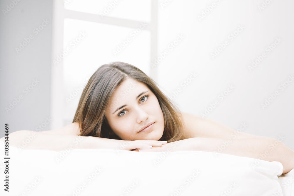 Young woman relaxing on bed in bright room Young woman relaxing on bed in bright room