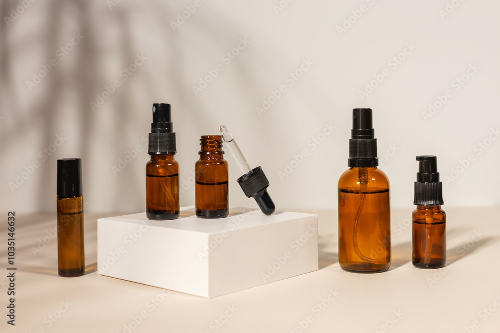 Massage essential oil in amber glass dropper bottle on podium on beige background. Natural SPA beauty product design Massage essential oil in amber glass dropper bottle on podium on beige background. Natural SPA beauty product design
