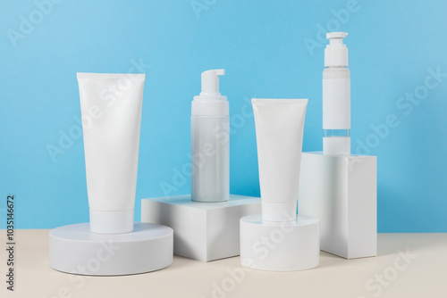 Beautiful cosmetic templates for ads, plastic cream tubes and bottles on a blue background with podiums.