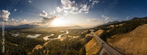 Aerial view of a tranquil sunset over the expansive wetlands and winding Columbia River surrounded by majestic mountains and serene forests, Invermere, Canada.