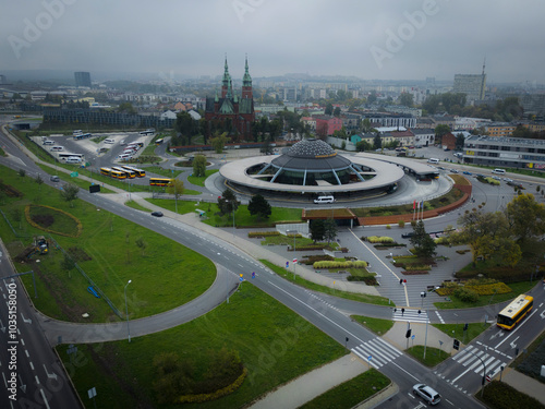 Aerial view of the church of the holy cross and bus station amidst urban architecture and greenery, Kielce, Poland. photo