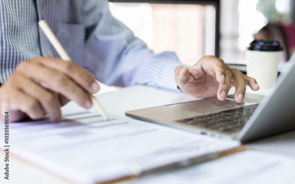 Fototapeta premium Asian businessman working with laptop at office. legal expert, professional lawyer checking business contract meeting online via laptop before giving advice to customers