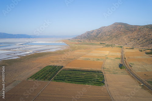 Aerial view of serene salt farm plots and fields with a mountain backdrop, Dazkiri, Turkey. photo