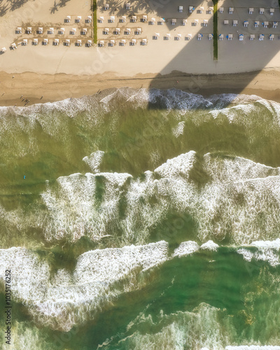 Aerial view of acapulco beach with tranquil waves and white sand under a sunny sky, guerrero, mexico.