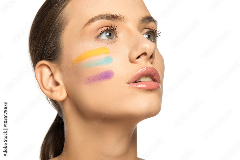 Beautiful young woman posing with different tones of eyeshadows on her face. Beautiful young woman posing with different tones of eyeshadows on her face.